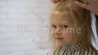 发型师理发师在美容院为一个可爱的小女孩做发型。 <strong>美发</strong>，理发..